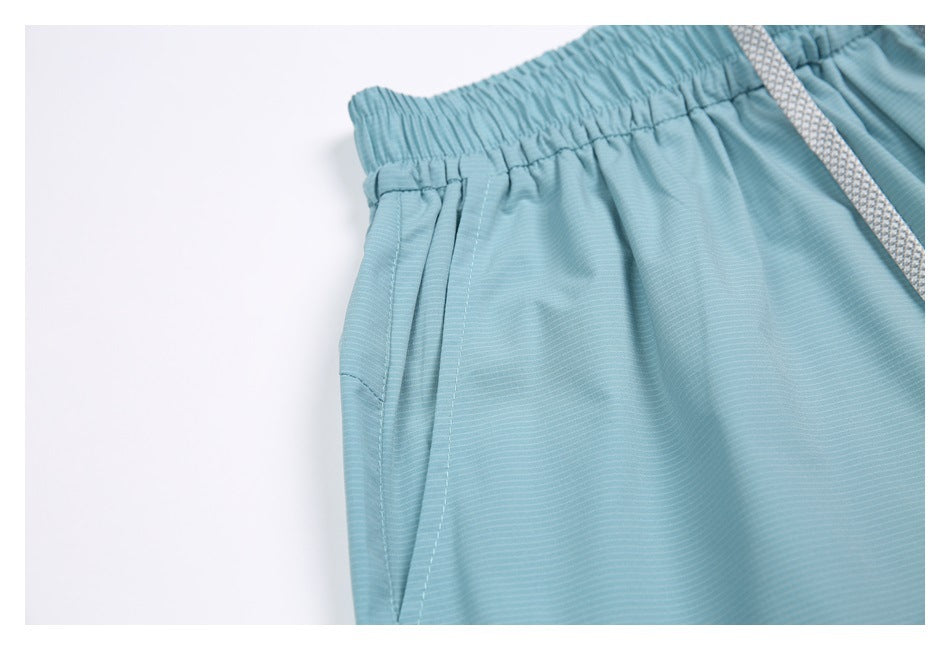 Close-up showing a side pocket and the elastic waistband on the light blue shorts.