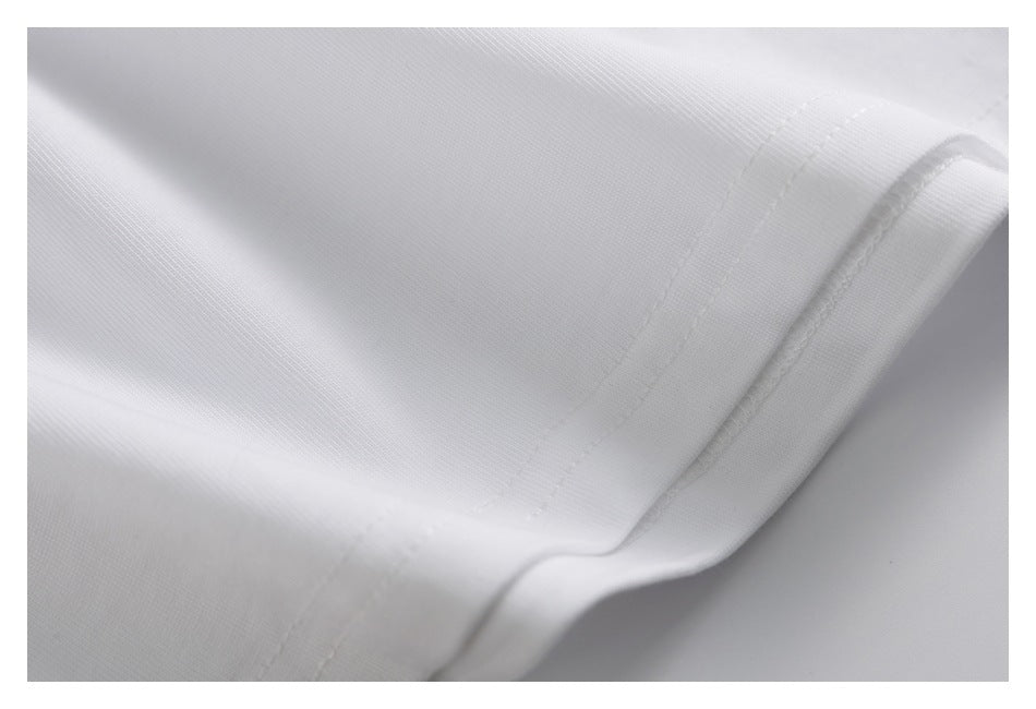Close-up of the stitched hem on white fabric, showing the fine knit texture and folded edge.