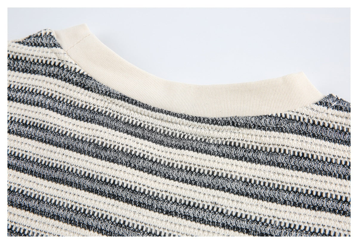 Close-up of the ivory ribbed crew neckline and black-and-ivory striped knit fabric.