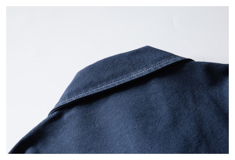Close-up of a dark navy garment collar with visible edge stitching and textured fabric.
