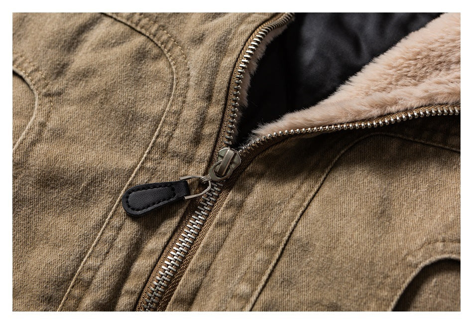 Close-up of a brown jacket's front zipper, black pull tab, and beige faux-fur lining.