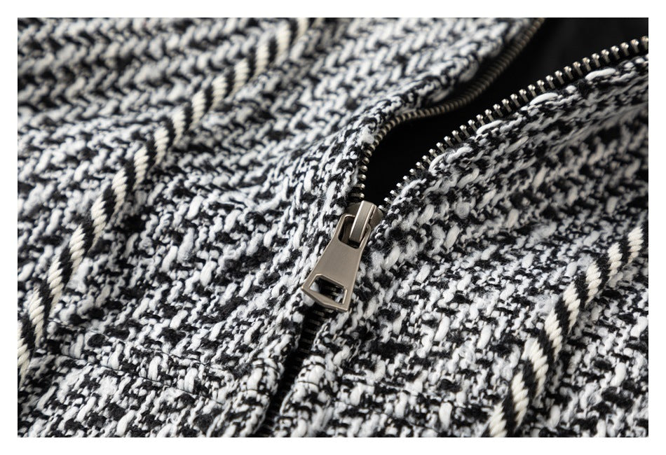 Close-up of a metal zipper on the textured black-and-white patterned garment.