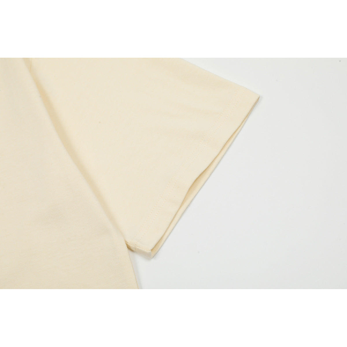 Close-up of the off-white T-shirt's short sleeve and double-stitched hem.