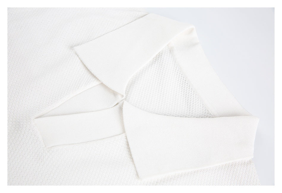 Close-up of the folded collar and textured fabric on a white polo shirt.