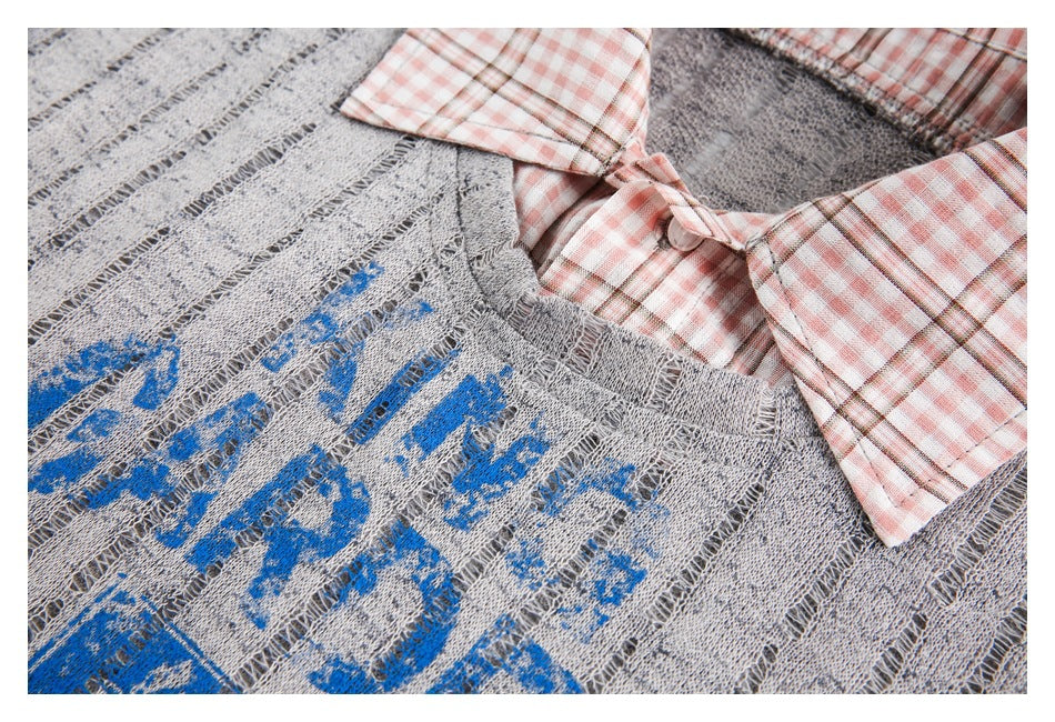 Close-up of blue graphic print and a pink plaid collar on a distressed gray open-knit sweater.