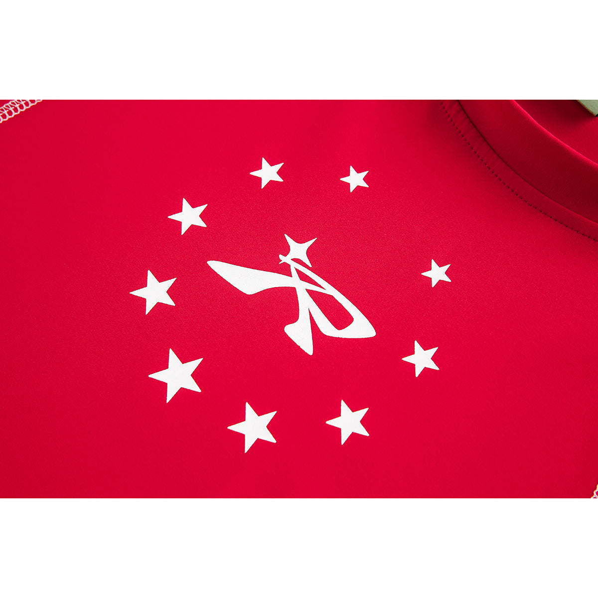 Close-up of a white star-and-emblem print on bright red shirt fabric.