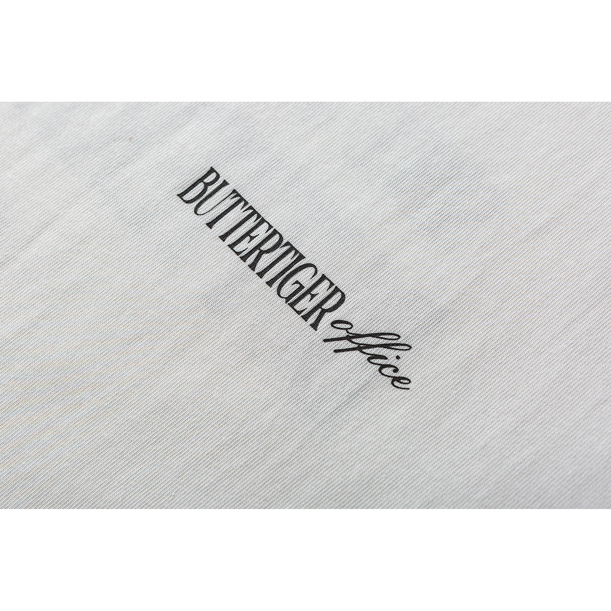 Close-up of white fabric with black “BUTTERTIGER office” lettering.