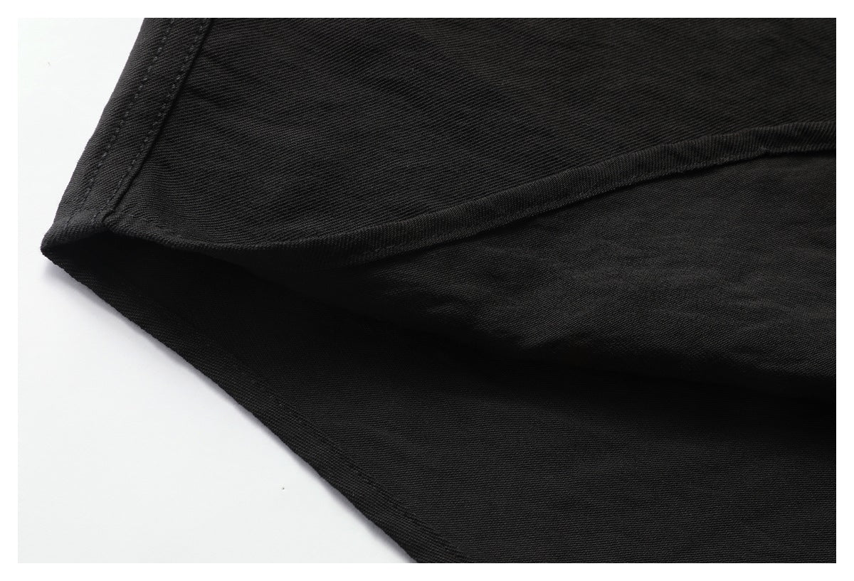 Close-up of a black garment's folded edge and stitched hem.