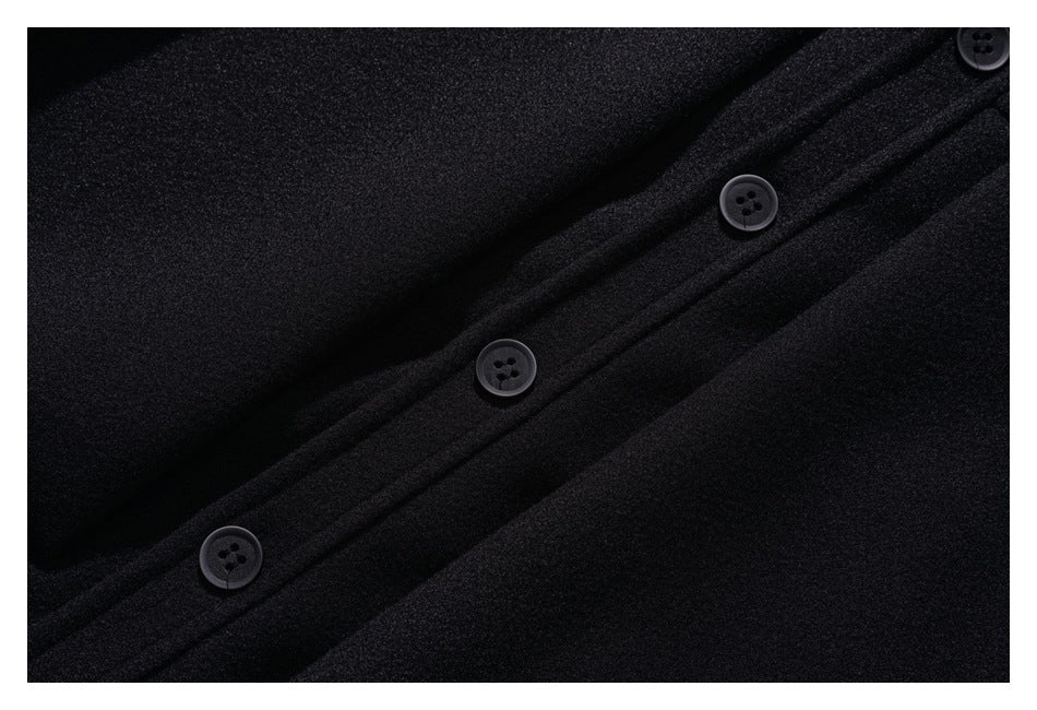 Close-up of the black coat’s buttoned front placket and seams.