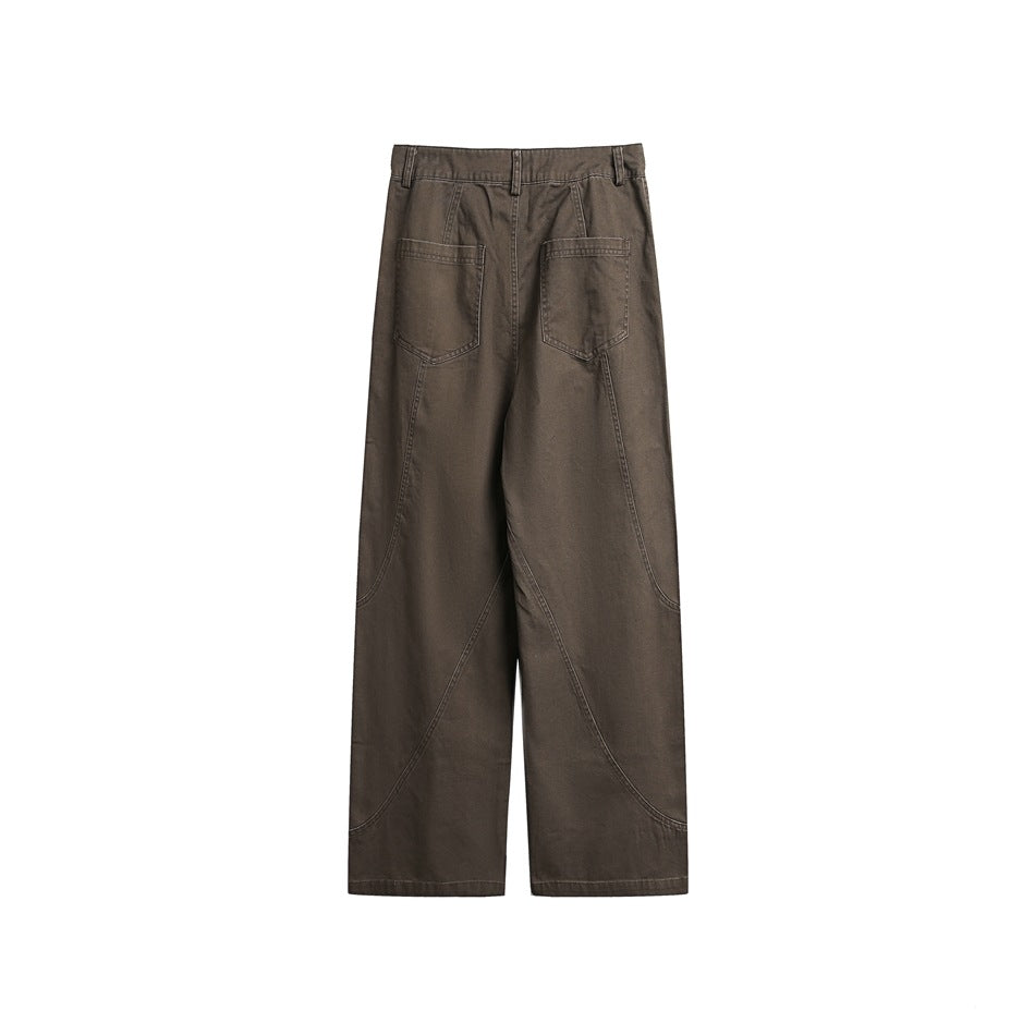 Back view of dark brown wide-leg pants with two patch pockets and curved panel seams, shown flat against white.