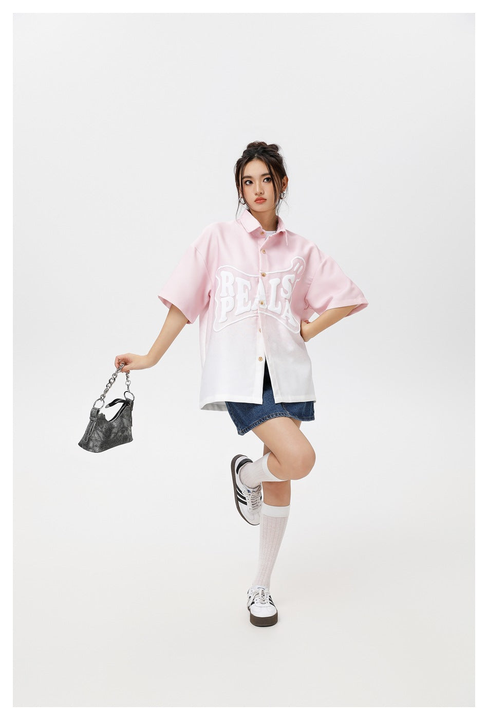 Model wearing a pink-and-white gradient short-sleeve button-up shirt with bold white PEALS lettering.