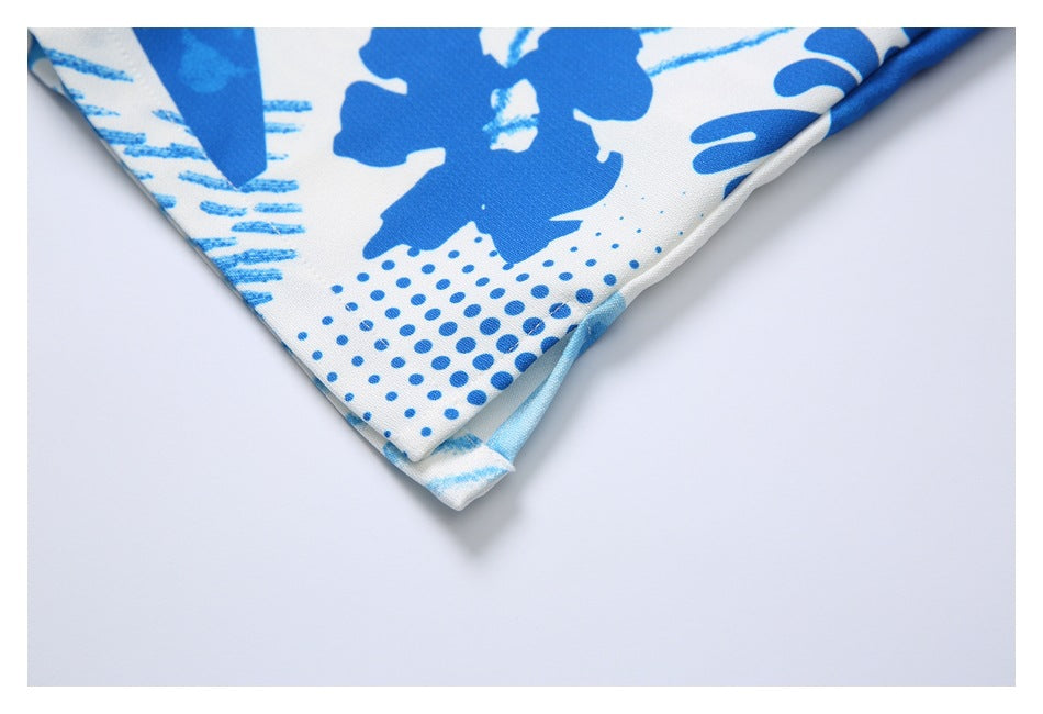 Close-up of a folded corner of white fabric with a bold blue abstract print.