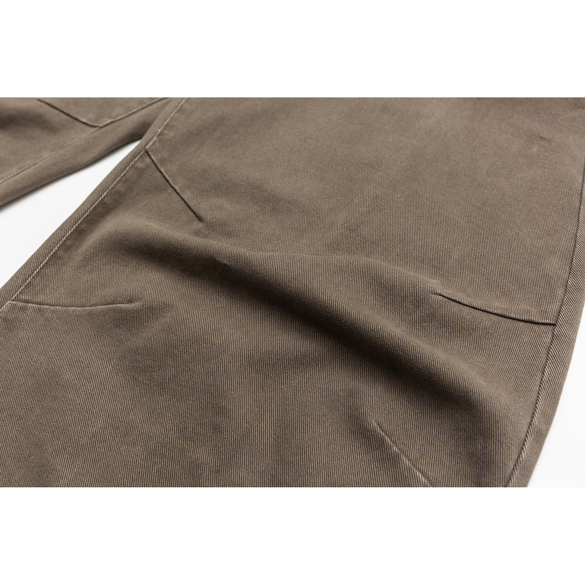 Close-up of taupe trouser fabric and seam stitching.