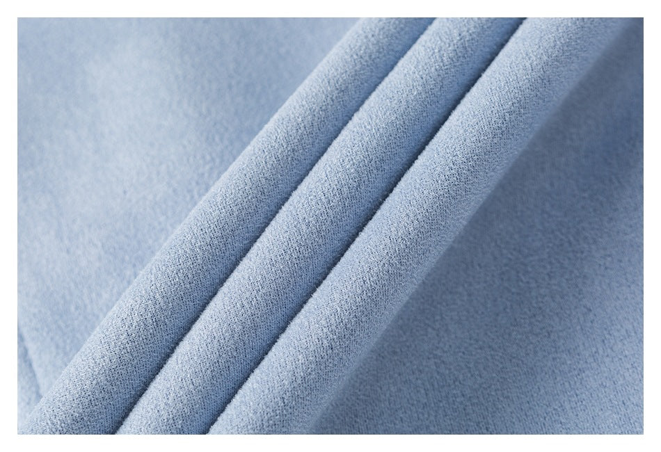 Close-up of folded layers of light blue jacket fabric showing the textured surface and edge.