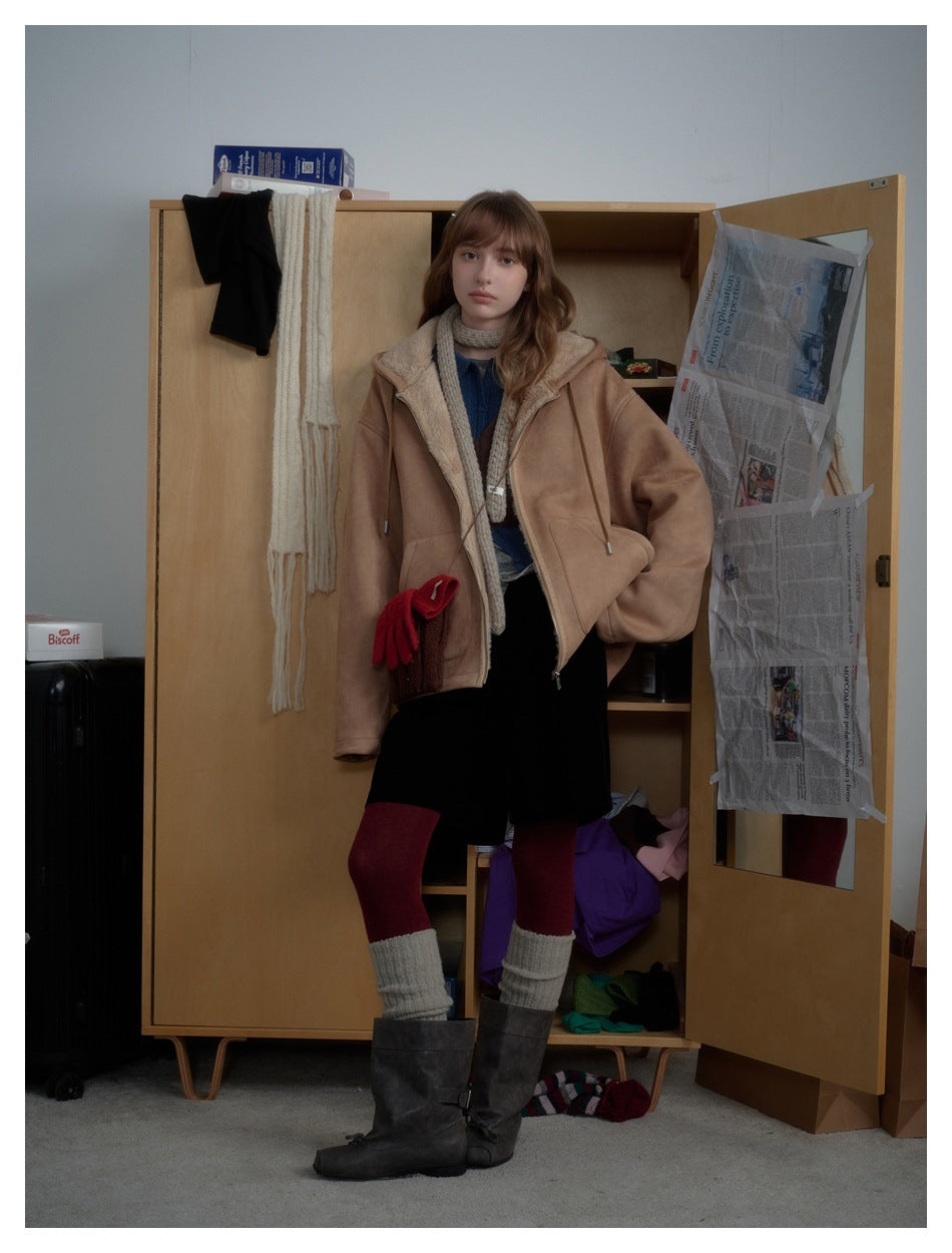 Model wearing the brown hooded zip jacket open with the plush hood lining visible, styled with a knit scarf and boots