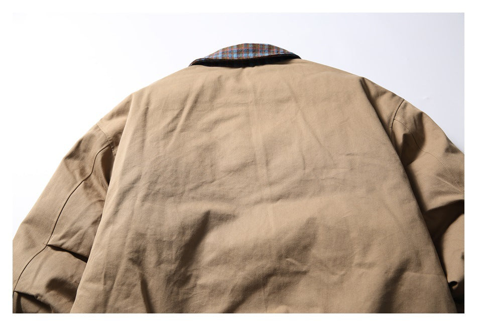 Back view of a tan jacket laid flat, with a blue-brown plaid collar.