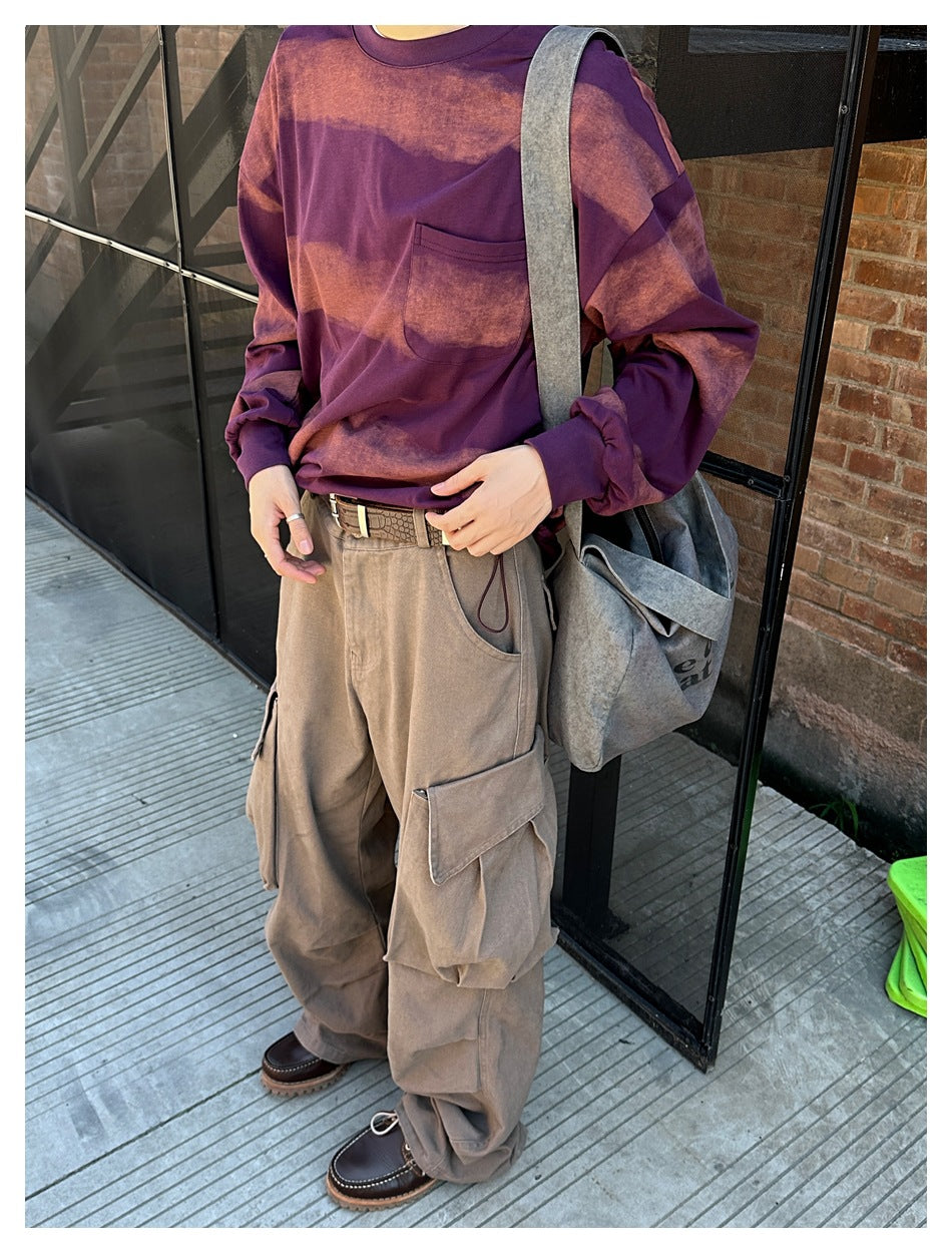 Close view of a person wearing khaki cargo pants with a flap thigh pocket, belt and gathered hem