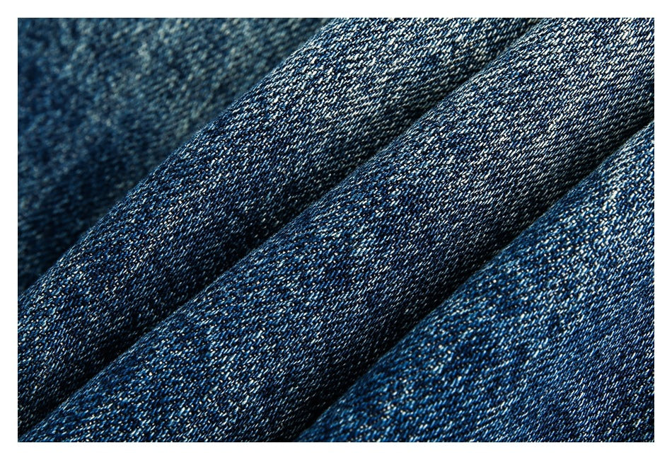 Close-up of dark blue twill fabric folded into ridges, showing its woven texture.