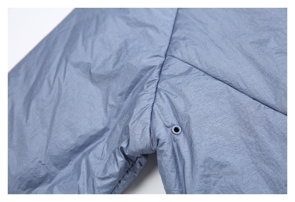 Close-up of a metal eyelet set into the blue-gray jacket near a seam.