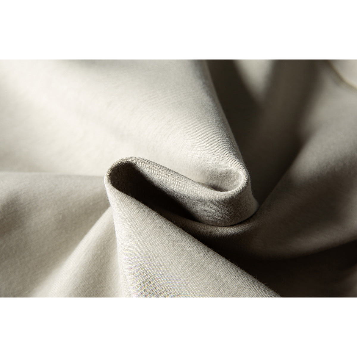Close-up of light beige sweatshirt fabric folded to show its surface and texture.