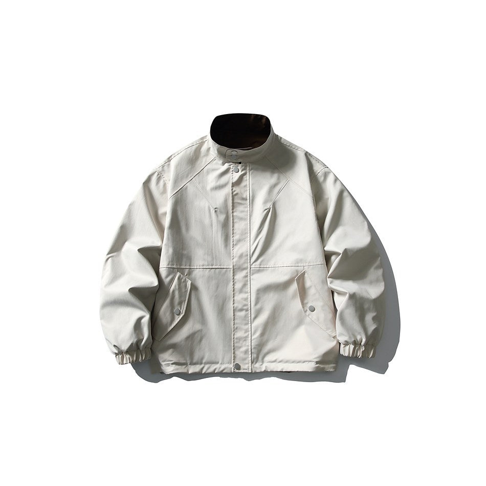 Front view of a light ivory jacket with a stand collar, snap-button placket, angled flap pockets, and elastic cuffs.