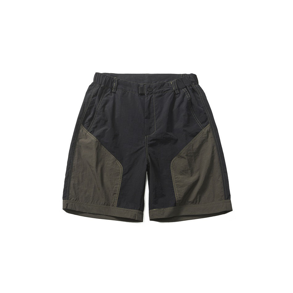 Black men's shorts with olive-green leg panels and hem band, elastic waistband and button tab closure, flat lay front view