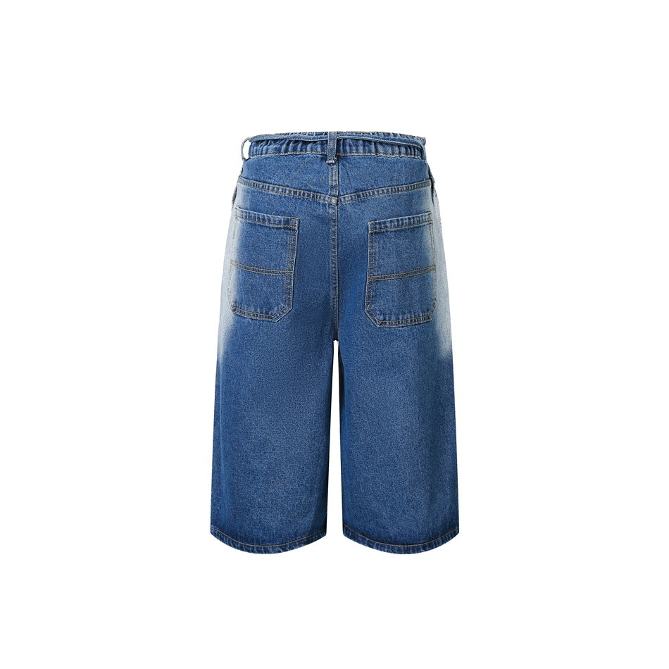 Back view of loose blue denim shorts with two patch pockets and faded panels along the outer sides.