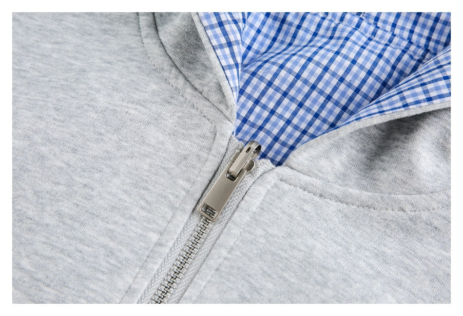 Close-up of the metal zipper and blue-and-white gingham lining on a light gray hoodie.