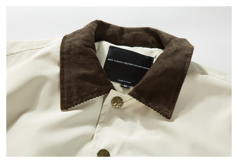 Close-up of an ivory jacket's dark brown corduroy collar, brass-tone button, and neck label.