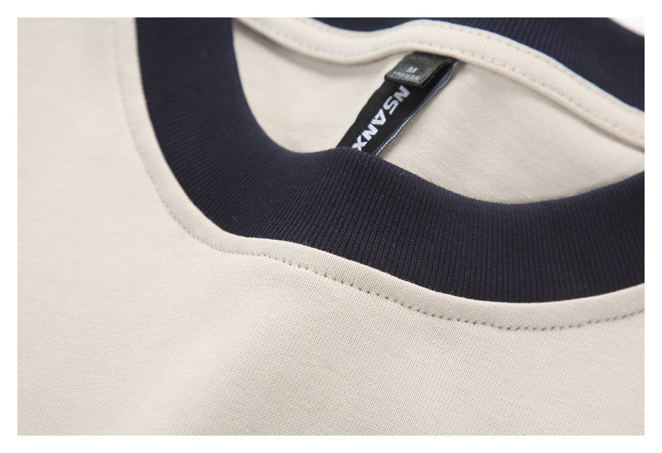 Close-up of the off-white shirt's dark ribbed neckline, stitching, and inner neck label.
