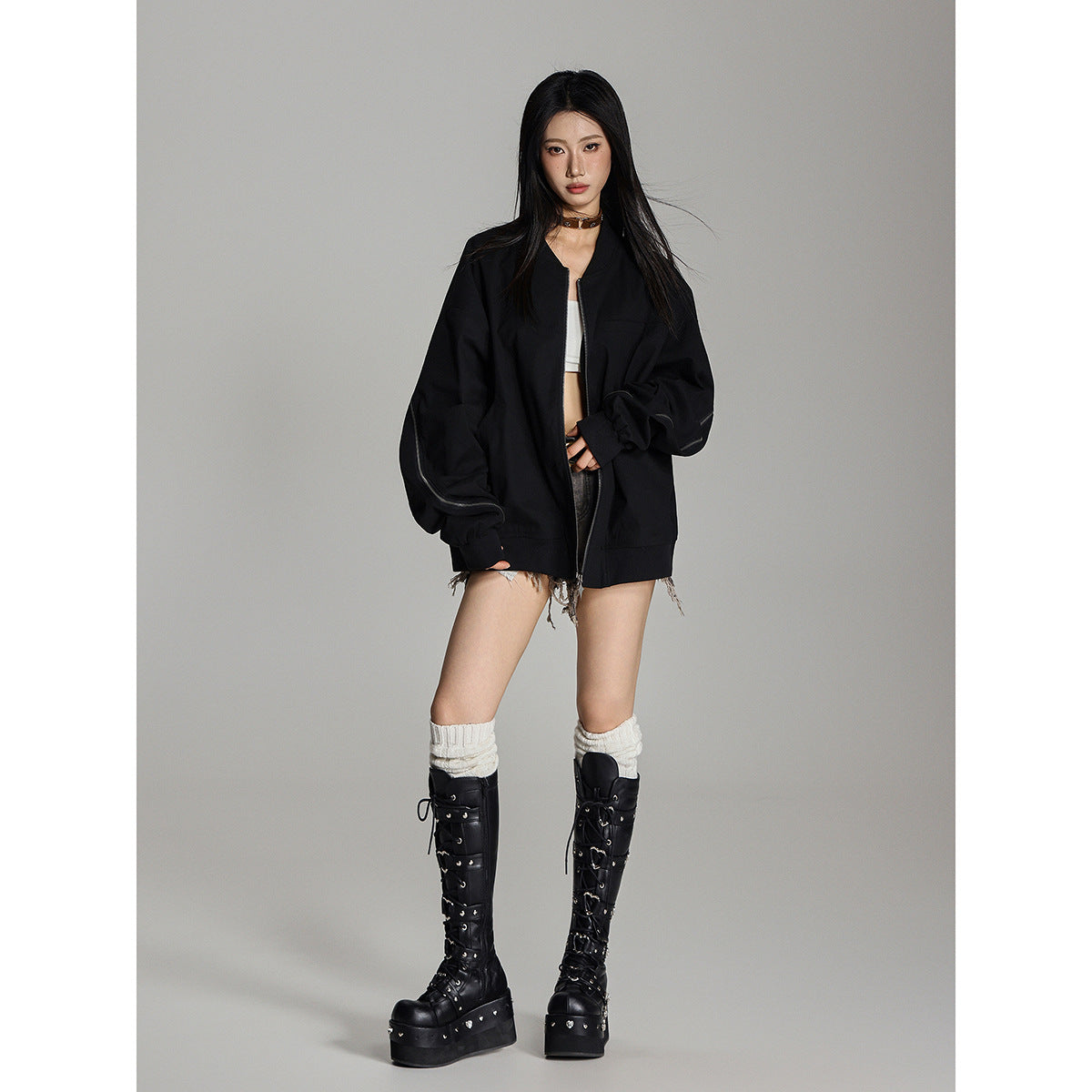 Full-length model wearing an oversized black zip-front jacket with zippered sleeves and ribbed cuffs and hem.
