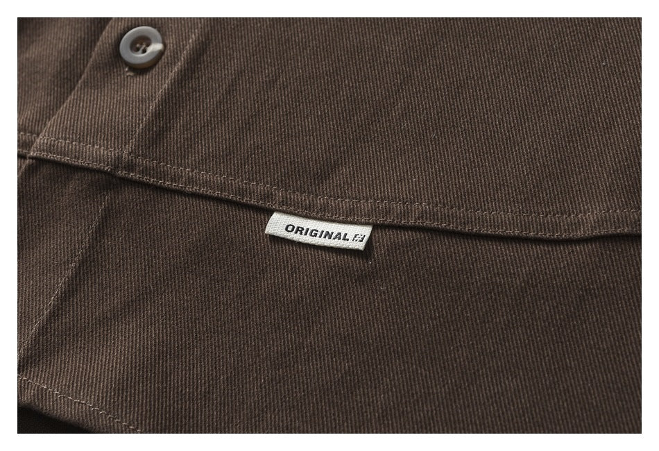 Close-up of dark brown garment fabric with a button, stitched seam, and a small ORIGINAL label.