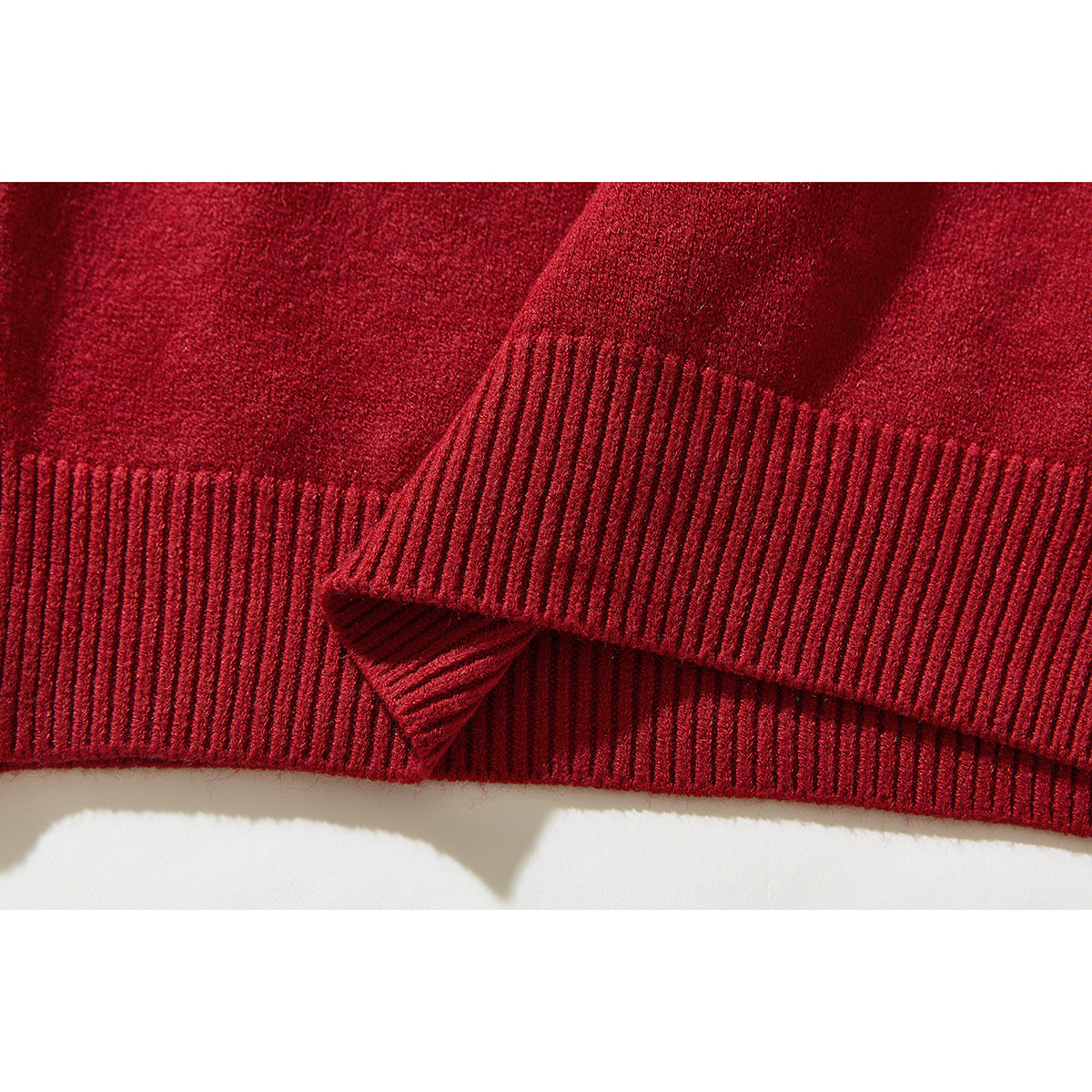 Close-up of the red sweater’s ribbed hem and cuff.