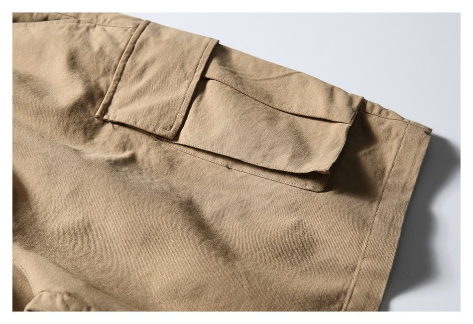 Close-up of a flap cargo pocket and hem on the tan shorts.