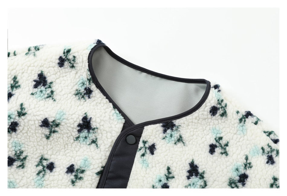 Close-up of the jacket's rounded neckline, dark edging and snap-button placket against the floral sherpa fabric.