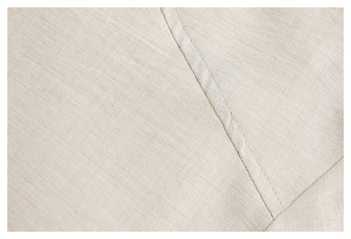 Close-up showing the ivory garment's woven-looking surface and a curved stitched seam.