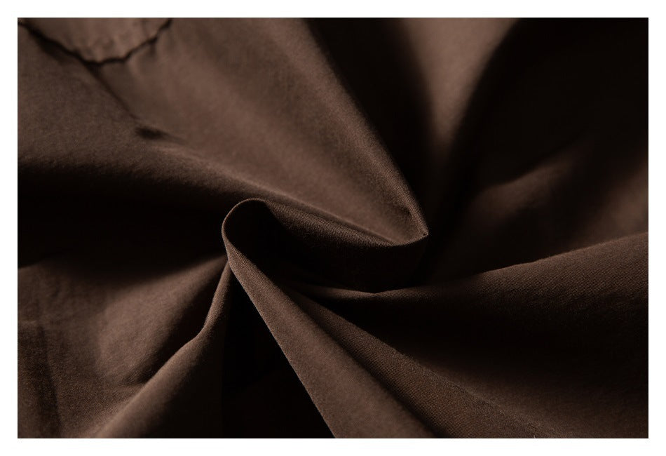 Close-up of dark brown fabric draped into soft folds.