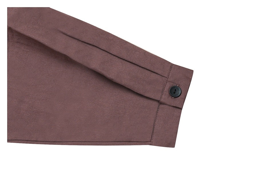 Close-up of a mauve-brown shirt sleeve ending in a buttoned cuff on a white background.