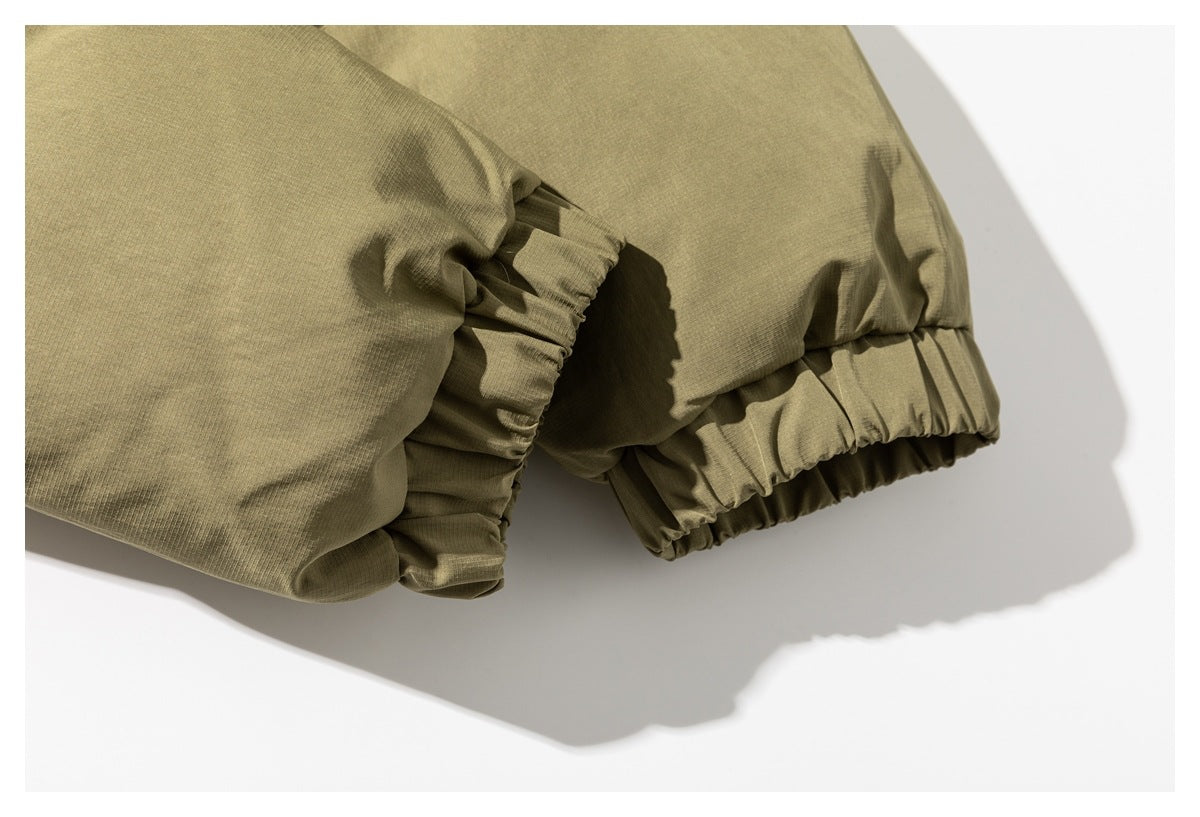 Close-up of olive fabric with gathered elastic edges and visible stitching.