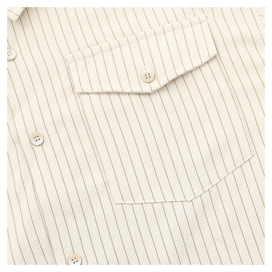 Close-up of the cream shirt's striped chest pocket and front buttons.