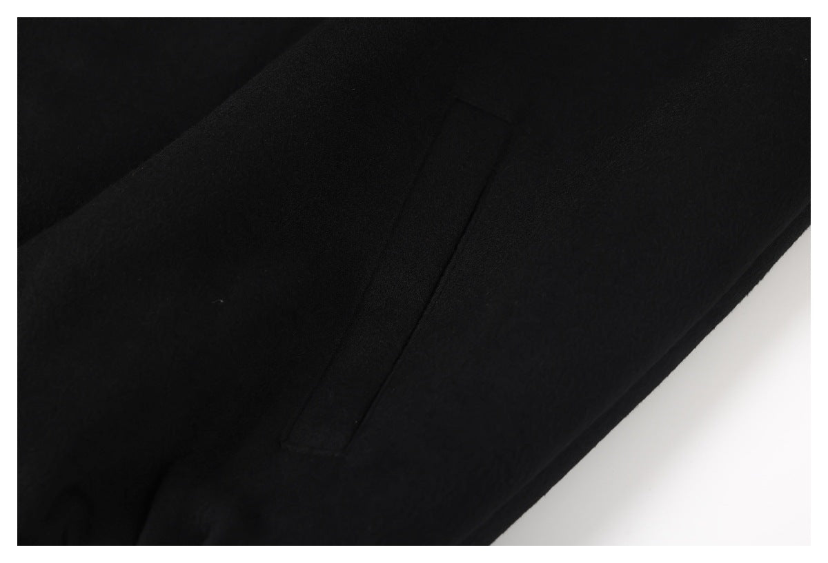 Close-up of a black jacket showing a narrow stitched pocket opening.