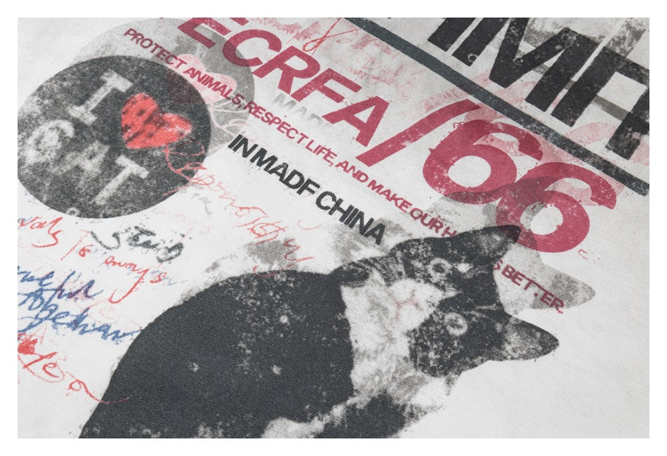 Close-up of distressed red and black lettering and cat artwork printed on an off-white T-shirt.