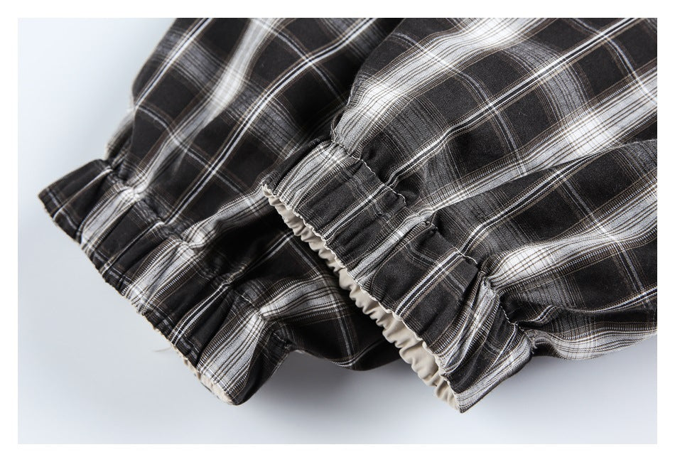 Close-up of the jacket’s gathered plaid sleeve cuff and light-colored inner lining.