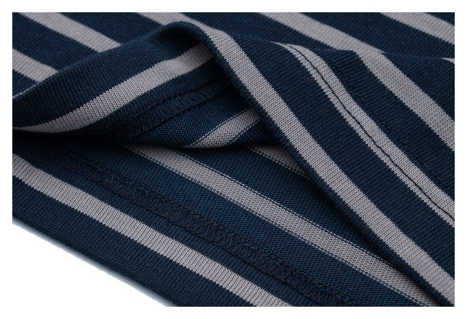 Close-up of striped fabric folded to show the T-shirt's hem stitching.