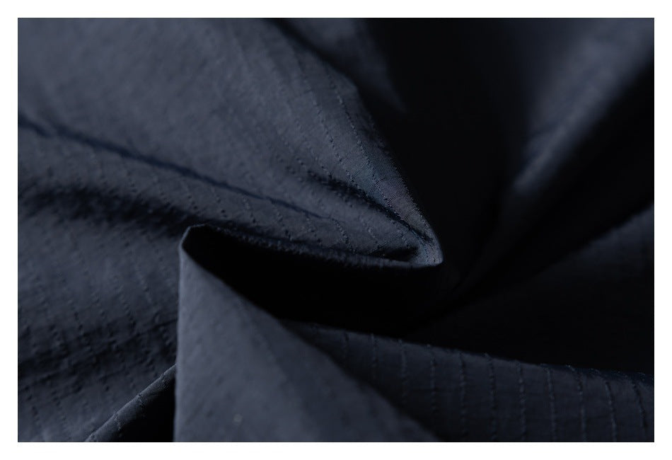Close-up of dark navy fabric showing stitched seams and a folded edge.