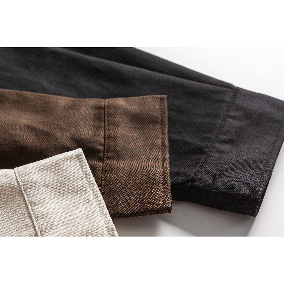 Close-up of shirt sleeve cuffs in cream, brown, and black.