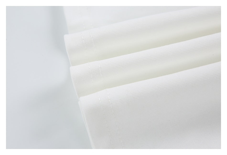 Close-up of white fabric folded into layers, showing a narrow stitched edge and fine texture.