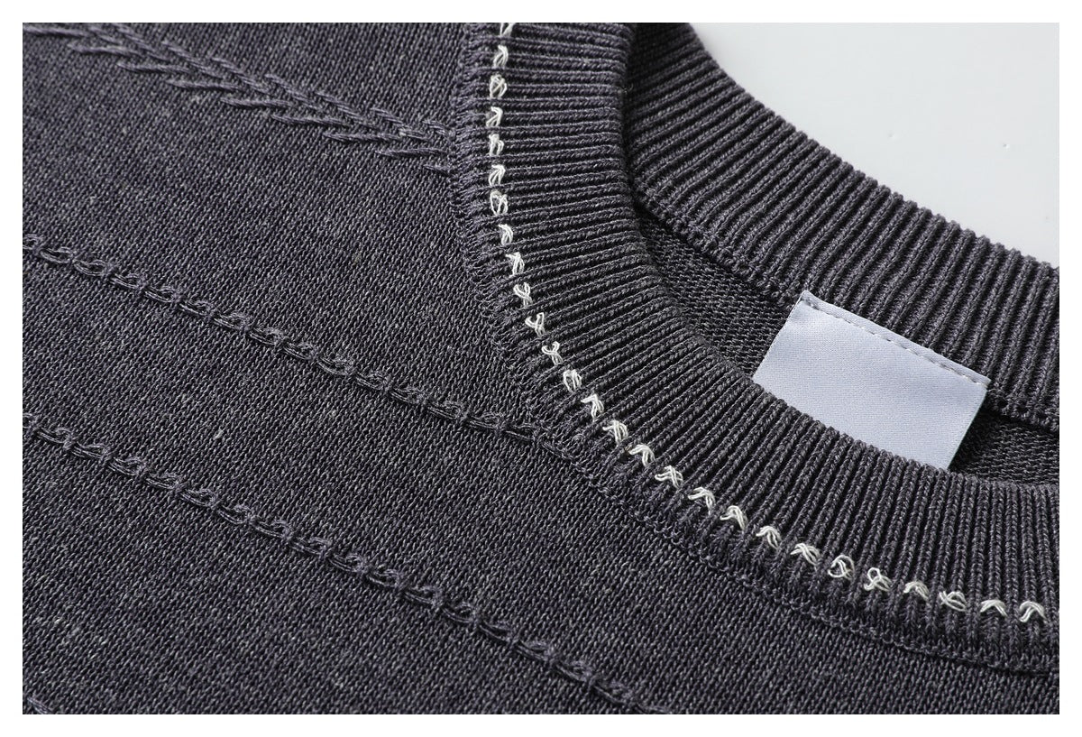 Close-up of a charcoal sweater's ribbed crew neck, light contrast loop stitching, and textured horizontal seams.