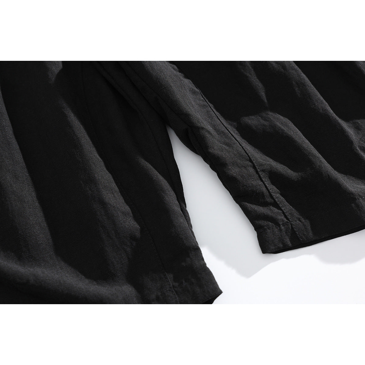 Close-up of the black shorts' leg panels and stitched hems.