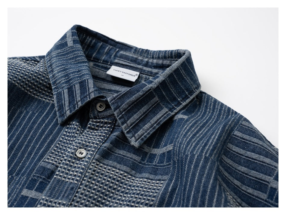 Front close-up of a blue patchwork-pattern button-up shirt with a pointed collar and textured placket.